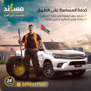 فني خدمة الطريق بجانب سيارته وإطار: مساعدة على الطريق وشحن البطارية